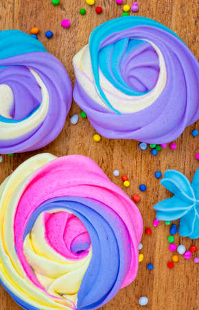 Colorful traditional homemade meringues on a wooden backgroundの写真素材