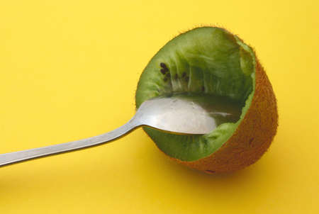 hollow kiwi with spoon on yellowの写真素材