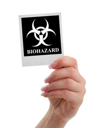 hand holding biohazard warning isolated on whiteの写真素材