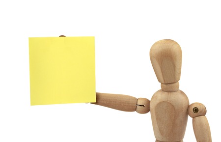 wooden figure holding empty adhesive note, all isolated on white backgroundの写真素材