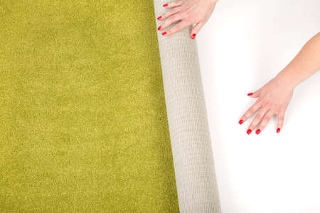 female hands unrolling a carpet isolated on white