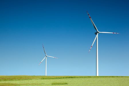 two wind turbines on green field