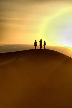 sunset over sand dunes, poeple are not identifableの写真素材