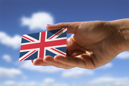 hand holding small flag of  Great Britainの写真素材