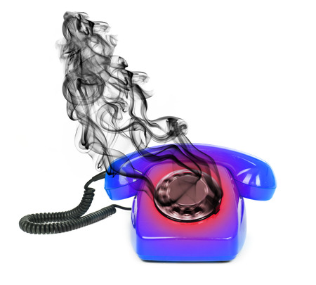 concept of hot line - overheated phone with smoke over white b ackgroundの写真素材