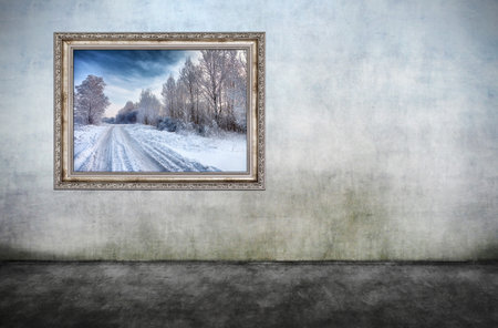 Old wooden frame with beautiful winter landscape on dirty wall. There is no copyright infringement,...