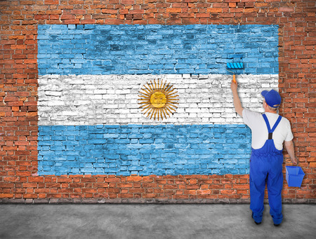 House painter paints flag of Argentina on old brick wallの写真素材