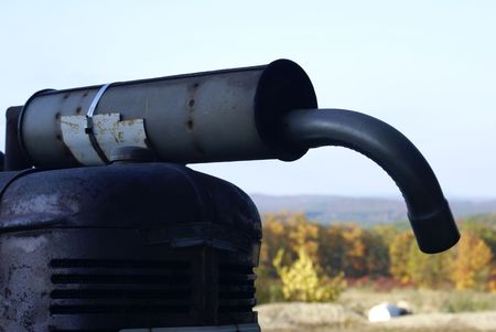 an antique rusty muffler on an old farm tractorの写真素材