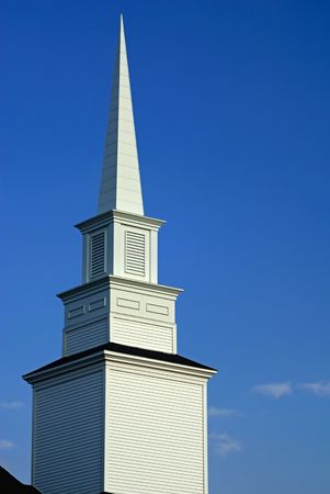 a white church steeple reaches high into the blue skyの写真素材