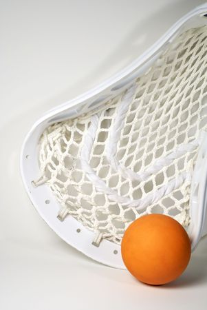 a white lacrosse stick head and an orange ballの写真素材