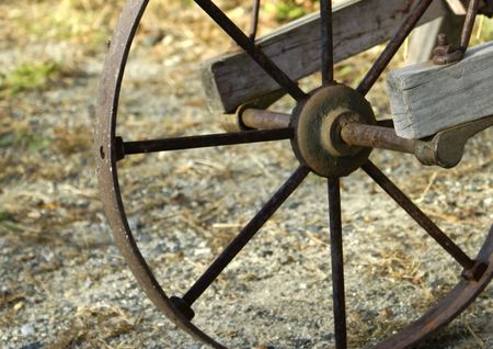 a vintage wood cart with a rusty metal wheelの写真素材