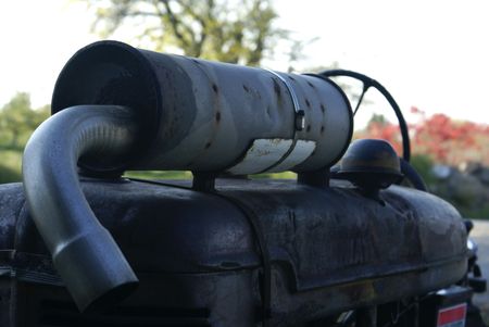 an antique rusty muffler on an old farm tractorの写真素材