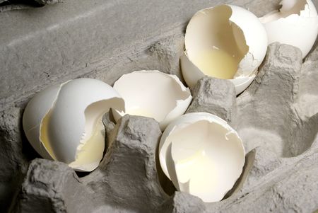 broken egg shells in a cardboard egg crate