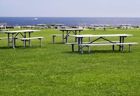 empty picnic tables at a park beside the oceanの写真素材