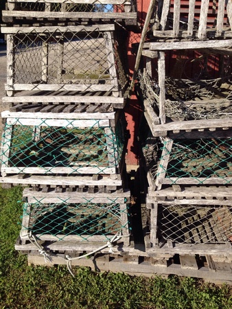 Old wood lobster traps with nets stacked in a pileの素材