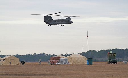 GEORGETOWN, SC - March 8, 2015:  A U.S. Army National Guard Chinook helicopter hovers over a portable air traffic control installation during Operation Vigilant Guard, a disaster drill simulating a Category 4 hurricane making landfall on the South Carolinのeditorial素材
