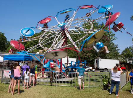 MATTHEWS, NC - September 4, 2017: Young people enjoy a carnival ride in the midway at the 25th annual "Matthews Alive" street festival.のeditorial素材
