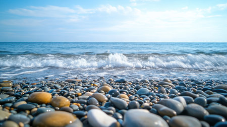 The ocean is calm and the rocks are scattered across the beach. The water is a deep blue color and the sky is clearの素材