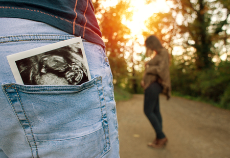 Pregnant woman in forest waiting for husbandの写真素材