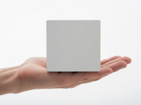 A single white cube held in an open handの素材