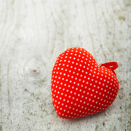 polka dots textile heart on wooden surfaceの写真素材
