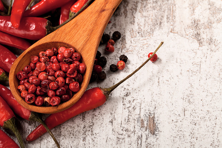 chili pepers and black pepers in spoon