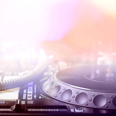 dj equipment in blurred background with disco lights