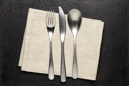silverware and napkin lying on old rustic backgroundの写真素材