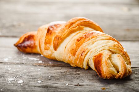 Tasty oil croissant lying on old wooden tableの写真素材