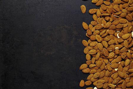 almonds lying on old rustic background. With place for copyの写真素材
