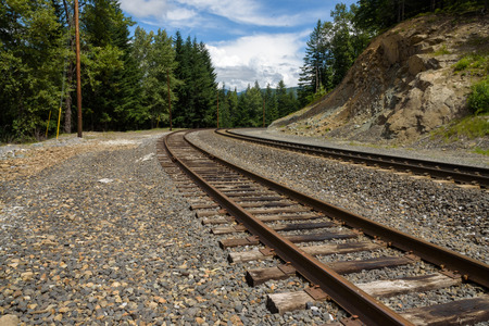 Two sets of train tracks curving into the landscapeの写真素材