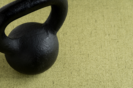 Black iron kettle bell on a light green backgroundの写真素材