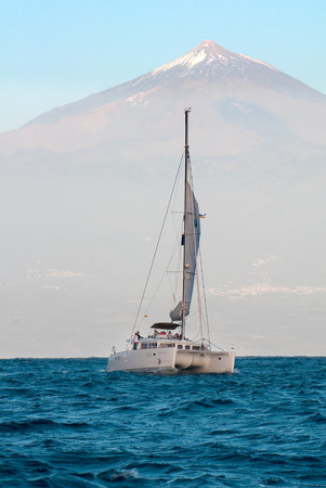 Catamaran in the ocean on a background of the volcano El Teide on Tenerife.のeditorial素材