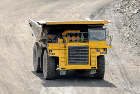 Yellow dump truck  driving on a road in a stone quarryの写真素材