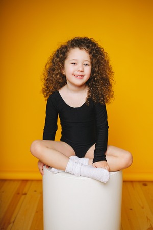 Funny curly little girl laugh in studio on orange background. Isolatedの写真素材