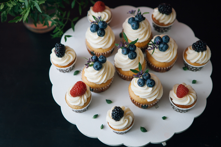 Cupcakes with berries on black table. Homemade. Copy-space. Indoorの写真素材