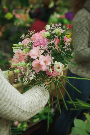 the woman florist is picking the bouquet. Natural. Flower shop. Indoorの写真素材
