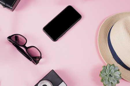 Overhead view of Traveler's accessories, Flat lay photography of Travel concept. Hands with black nail design. Pink background. Copy-textの写真素材