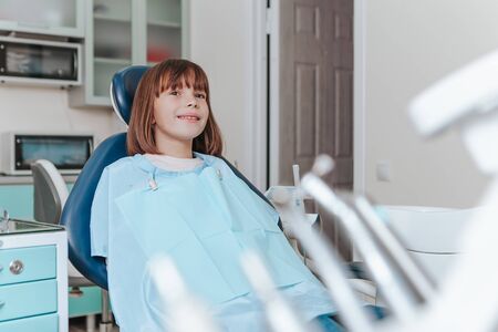 Patient girl is waiting for an examination on the dental chair. In dental officeの写真素材