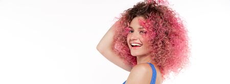 happy beautiful woman with pink curly afro hairstyle dancing and smiling in blue swimsuit. Flying...