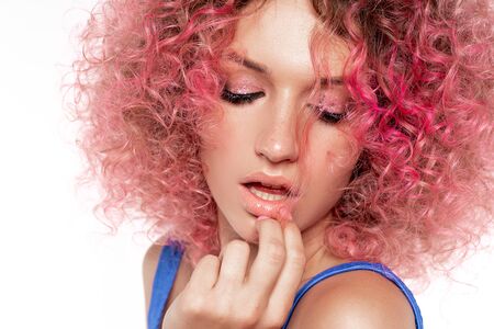 Portrait of beautiful woman with pink curly colored hairs in blue swimsuit. Glitter makeup. 90s style. Ombre. Isolated on white background.Perfect smileの写真素材