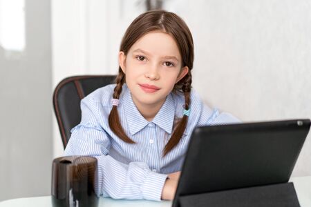 Young girl learn by tablet at home. Distance learning in quarantine. Isolation. Homework
