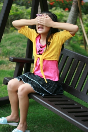 A young girl playing at a greenery field の素材