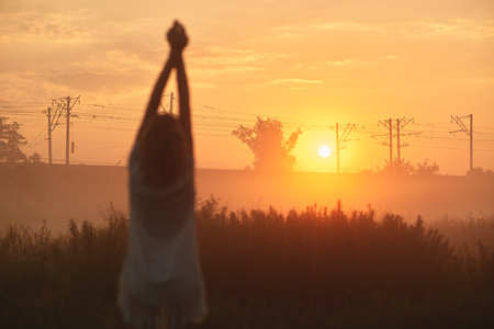 Pretty young woman in field at sunsetの写真素材