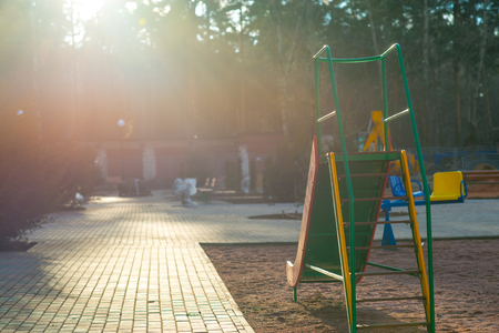 children's slide against the Sun and background of woodの写真素材