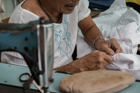 Local tailor works in textile ,is sewing a fabric .This 's shot take in Thailand.