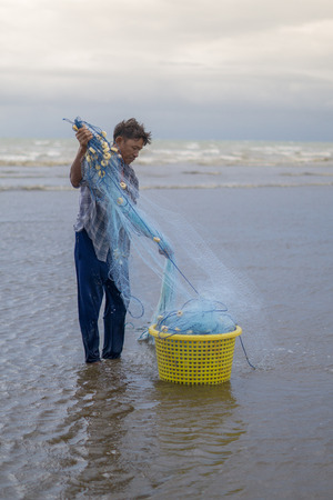 July 12 2017 - Chantaburi ,Thailand - Fisherman are reparing fishing net on the beach in sunset.のeditorial素材