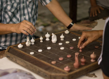 Man are playing old a chess board on wooden table.の写真素材
