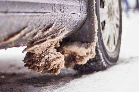 Wheels car caked with snow after a heavy snowstorm. Car covered with ice after freezing rain.の写真素材