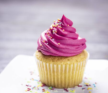 cupcakes with cheese cream and small decorative balls